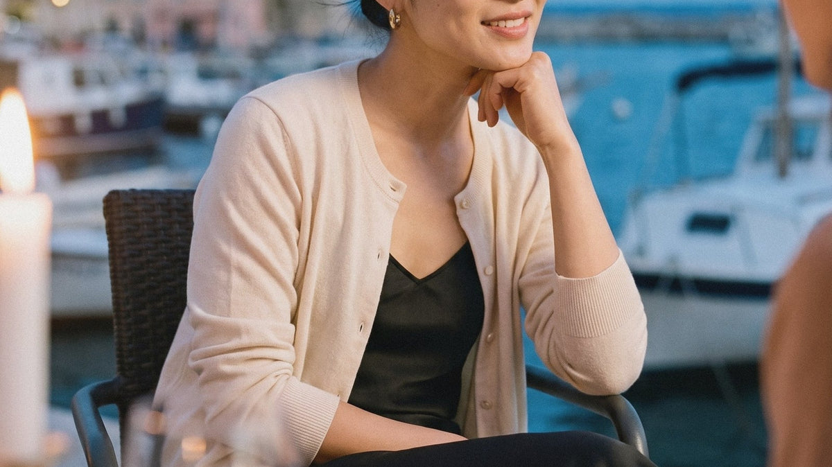 Woman in a cream cardigan and silk skirt at an evening dinner
