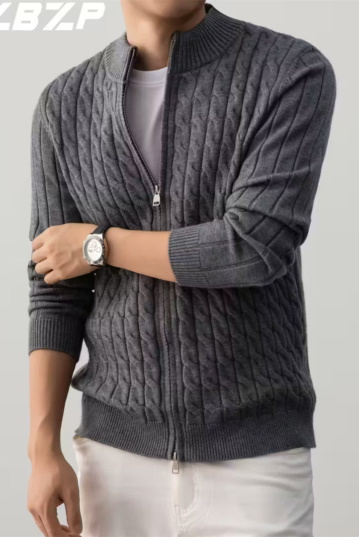 Person wearing a gray cable knit sweater with a zipper on a light gray background