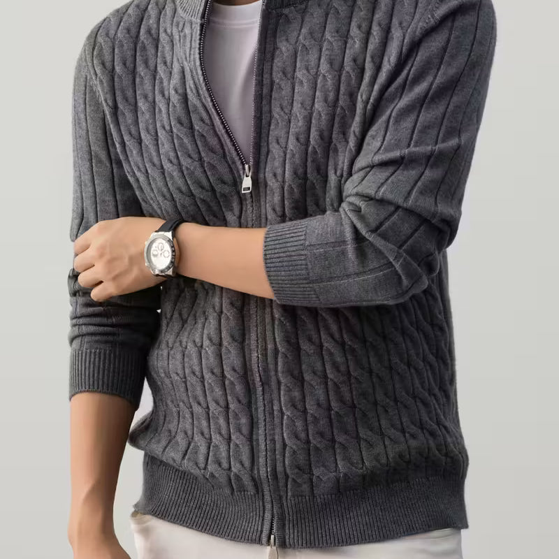 Person wearing a gray cable knit sweater with a zipper on a light gray background