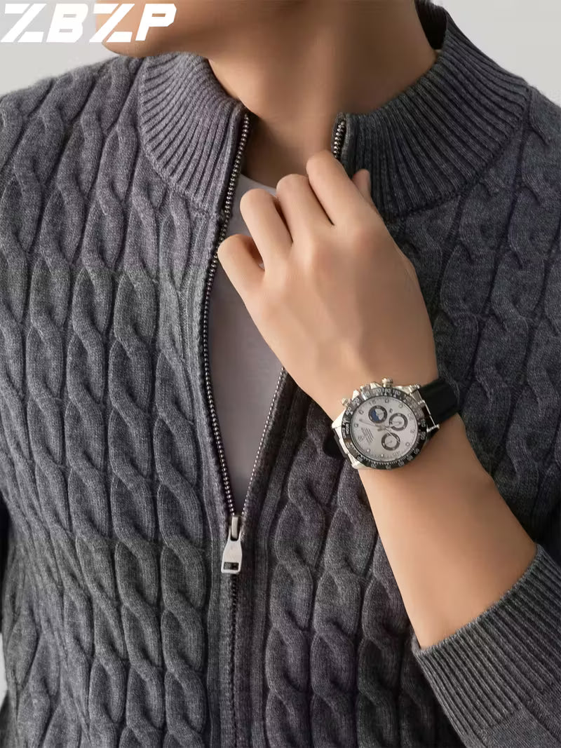 Person wearing a gray cable knit sweater with a watch on a neutral background