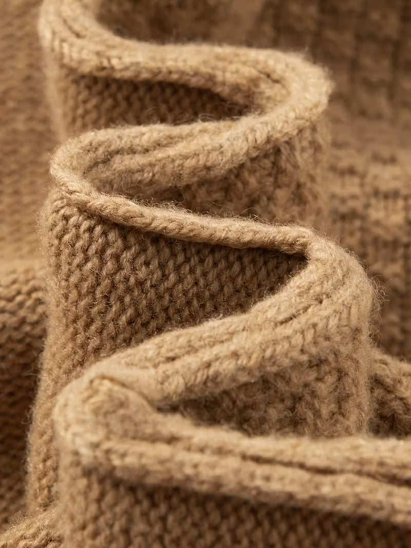 Close-up of a knitted brown fabric with a textured pattern.