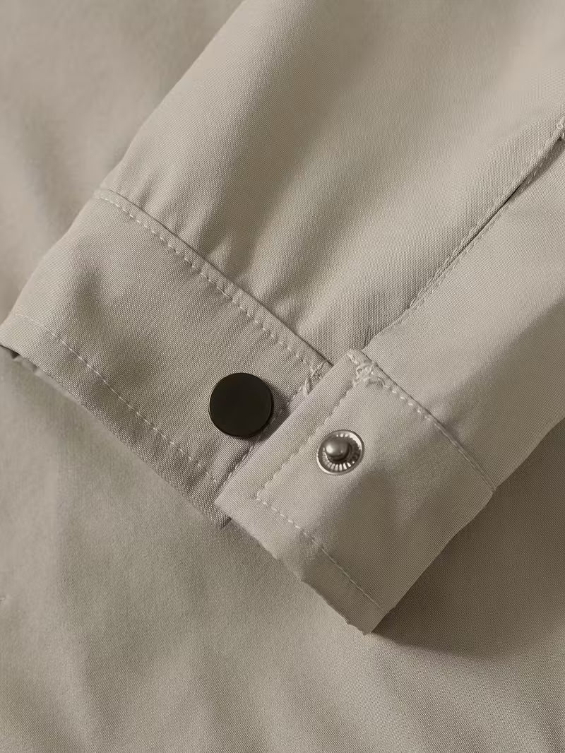 Close-up of a beige shirt with buttons on a neutral background