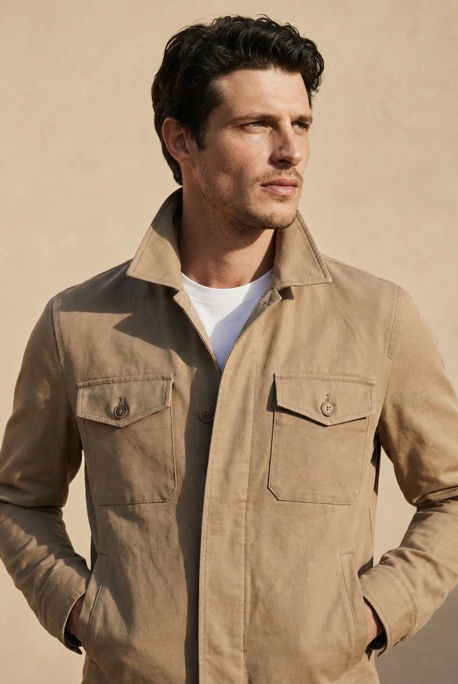 Man wearing a beige jacket against a beige background