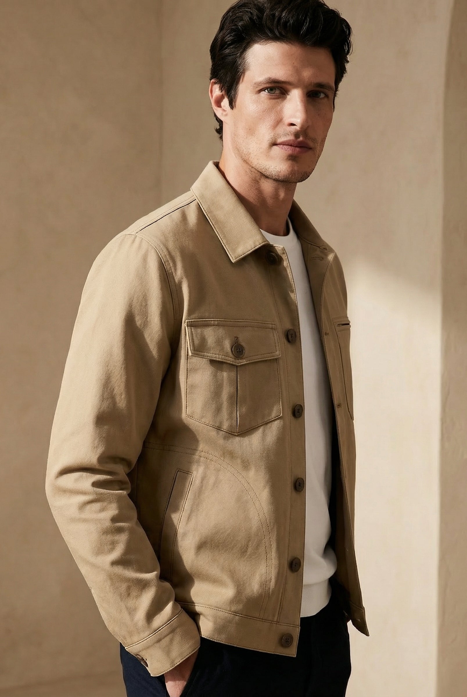 Man wearing a beige jacket against a beige wall