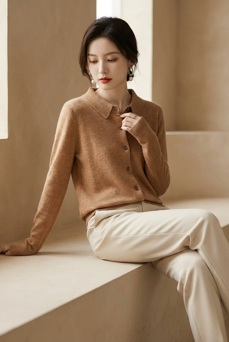 Woman wearing a brown sweater and beige pants sitting on a windowsill.