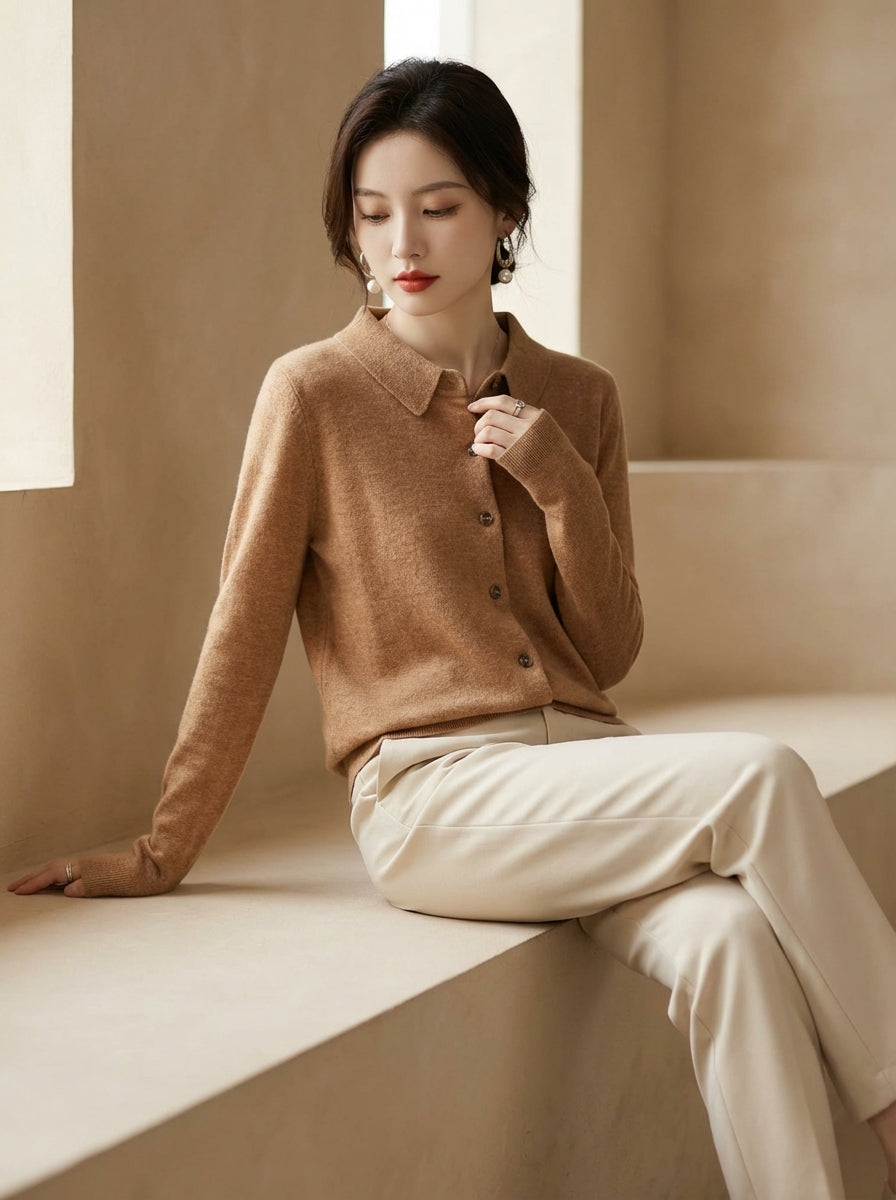 Woman wearing a brown sweater and beige pants sitting on a windowsill.