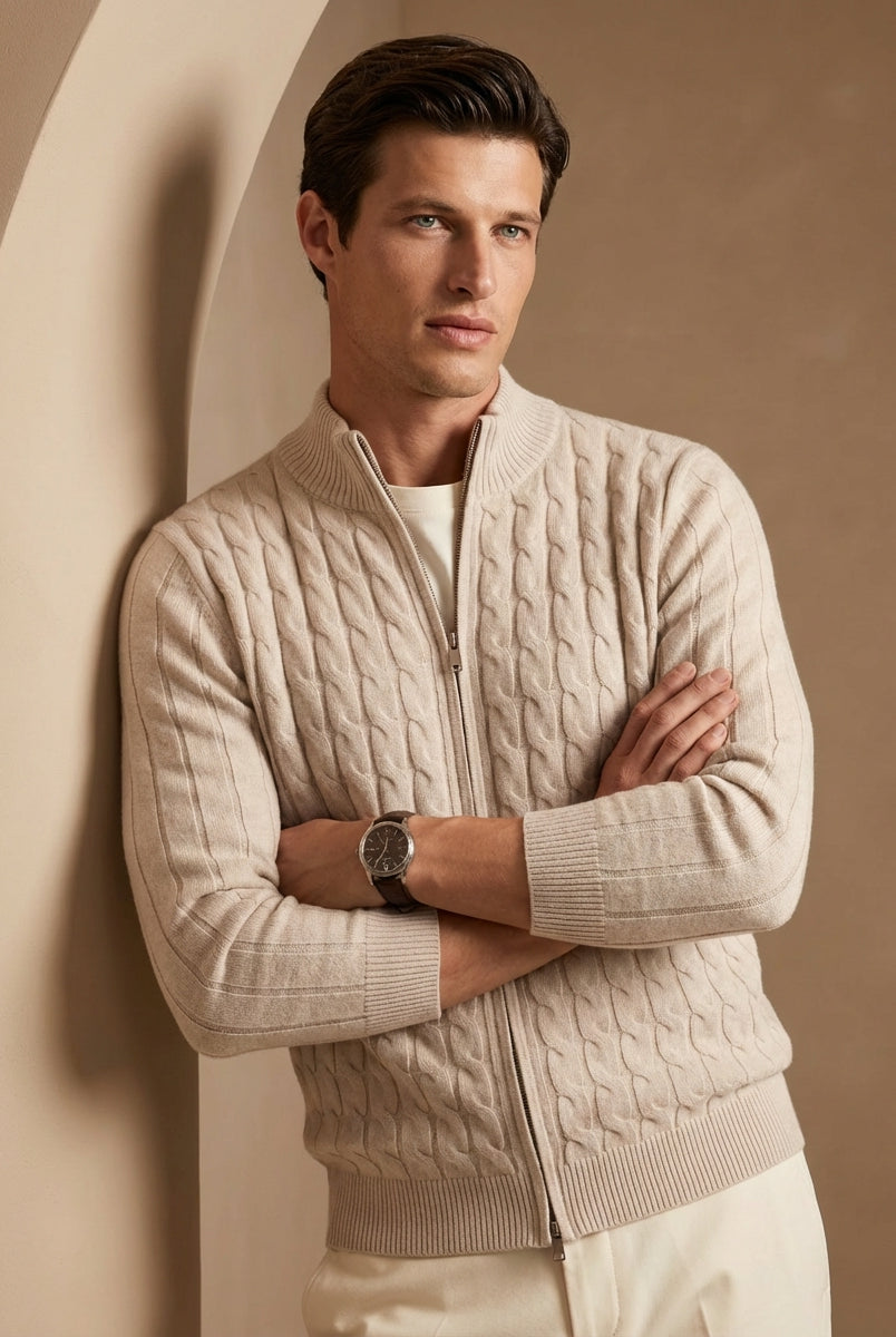 Man wearing a beige cable knit sweater against a beige wall