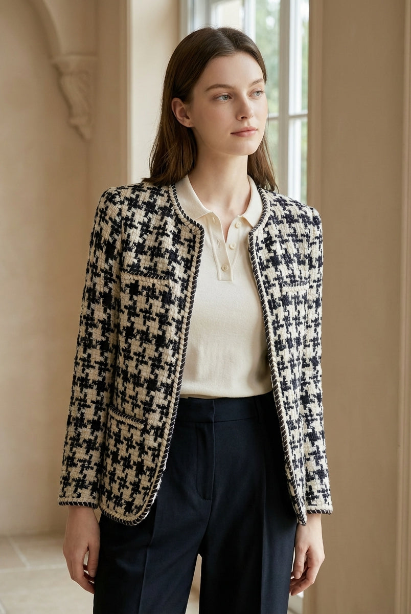Woman wearing a black and white checkered jacket in an indoor setting