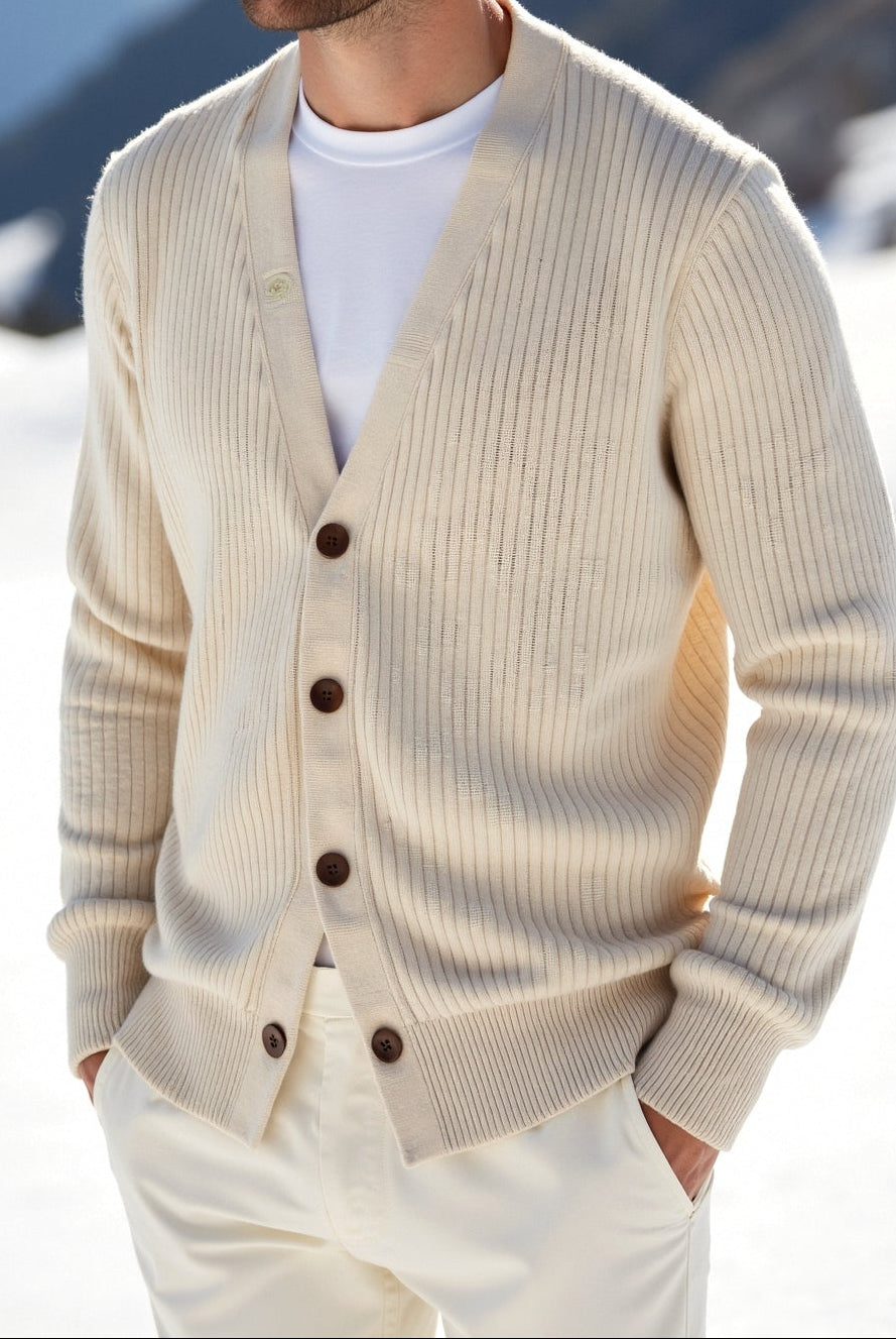 Man wearing a beige cardigan in a snowy mountain landscape