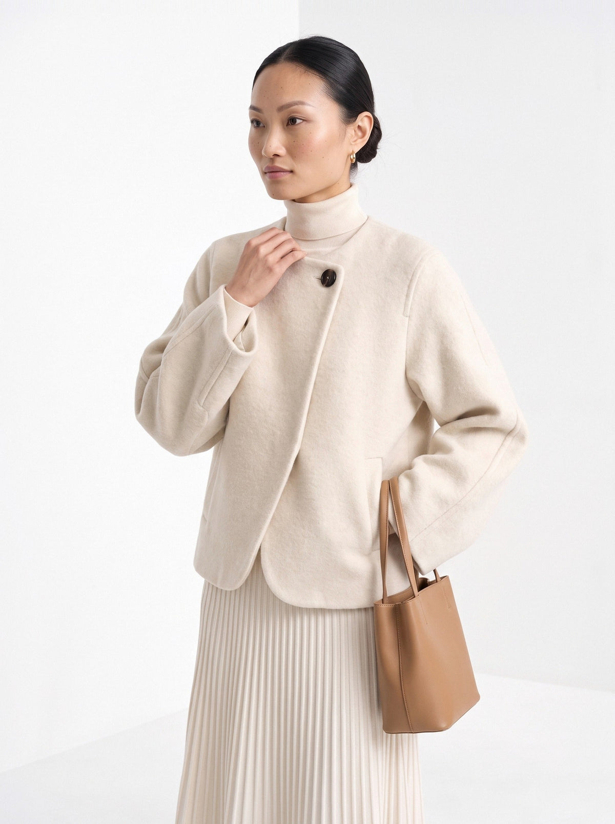 Woman in a cream collarless short coat and white turtleneck, BLENIN women's autumn collection