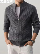 Person wearing a gray cable knit sweater with a zipper on a plain background
