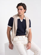 Men's diamond knit polo in navy and white, styled