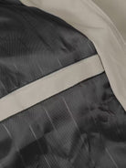 Close-up of a black and beige jacket with reflective striping.