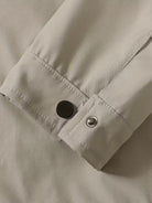 Close-up of a beige shirt with buttons on a neutral background