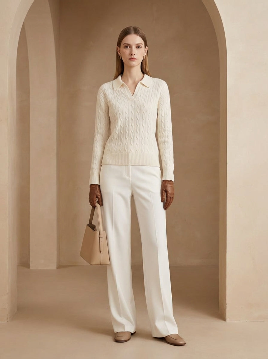 Woman in a cream-colored outfit standing in a beige archway
