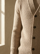 Close-up of a beige ribbed sweater with buttons against a neutral background