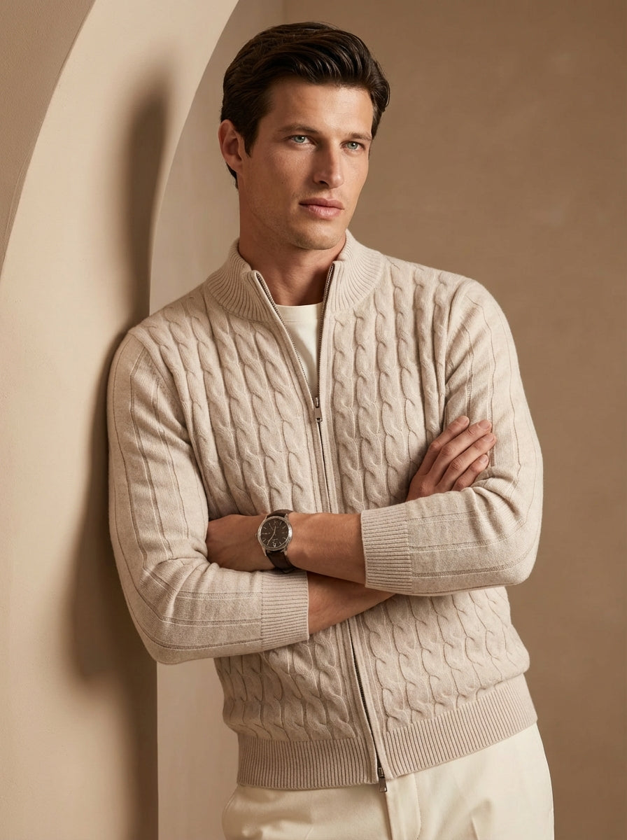 Man wearing a beige cable knit sweater against a beige wall