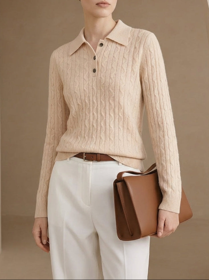 Woman wearing a beige ribbed sweater and white pants, holding a brown leather bag against a beige background.