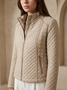Beige quilted jacket worn by a person against a neutral background