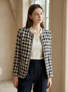 Woman wearing a black and white checkered jacket in an indoor setting