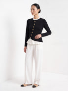 BLENIN gold button knit top in black, three-quarter view