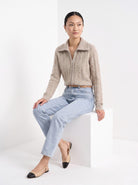 BLENIN cable zip collar cardigan in camel, seated, full outfit