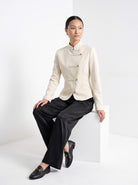 BLENIN stand collar fitted jacket in cream, seated, full outfit